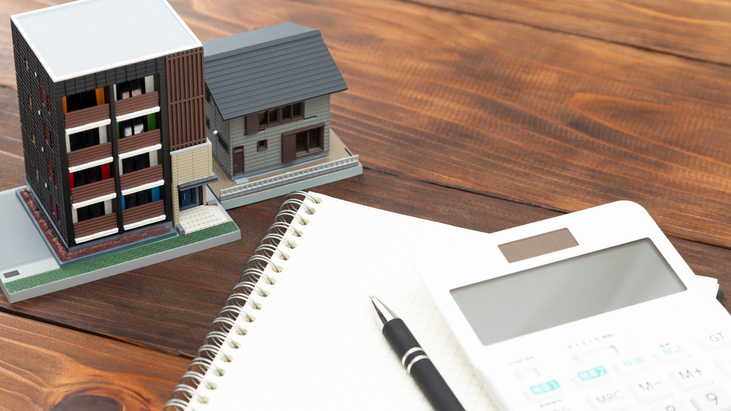 2つの家の模型と電卓